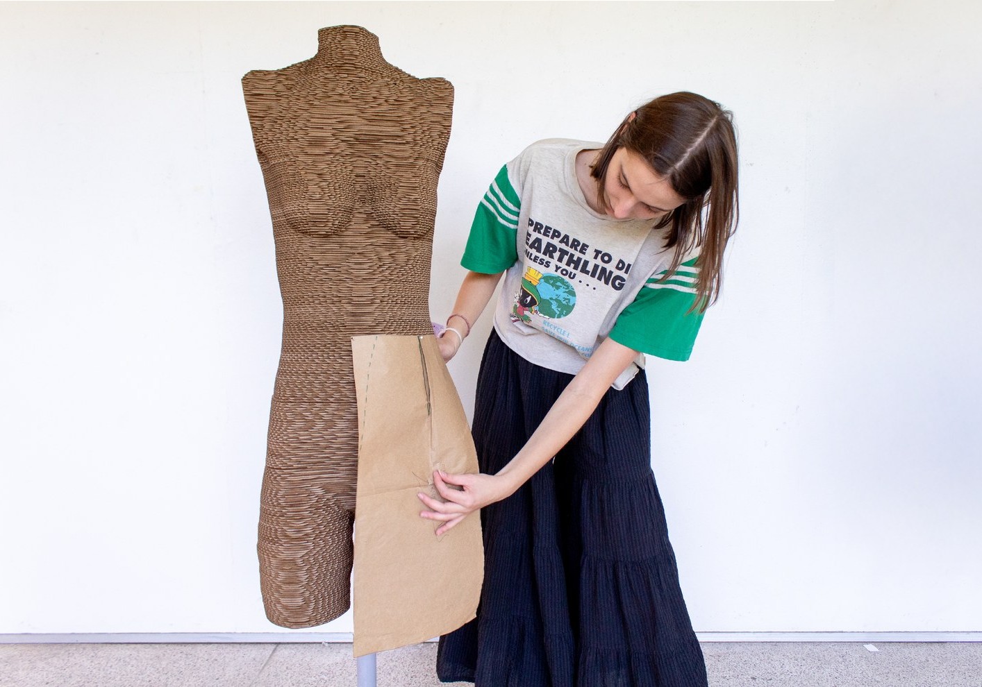 A maker fitting a paper pattern piece against a Your Form dress form
